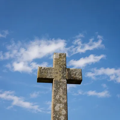 Weathered Stone Cross Under Blue Sky