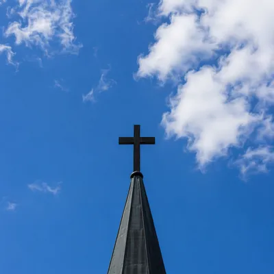 Cross on Steeple Against Blue Sky