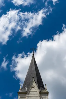 Empty Cross Steeple Against Blue Sky