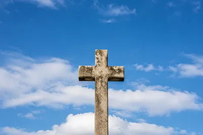 Weathered Stone Cross Under Blue Sky