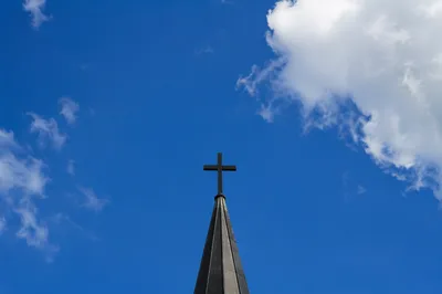 Cross on Steeple Against Blue Sky
