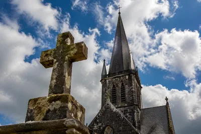 Empty Stone Cross Beneath Blue Cloudy Sky