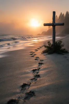 Footprints Leading to Driftwood Cross at Sunrise