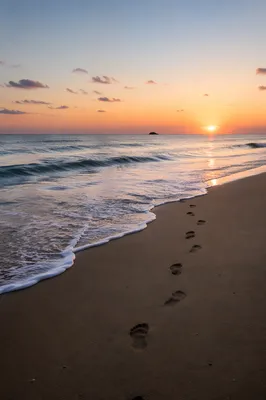 Footprints in Sand at Peaceful Beach Sunrise