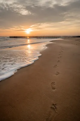 Sunrise Footprints Across Quiet Beach Sand