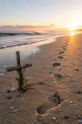 Footprints Toward Sunrise with Driftwood Cross