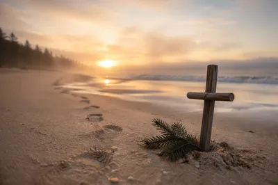 Beach Footprints at Sunrise With Driftwood Cross