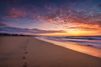 Footprints on Sandy Beach at Sunrise