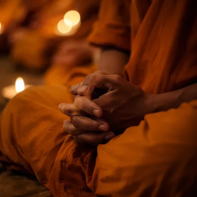 Folded Hands in Candlelit Prayer