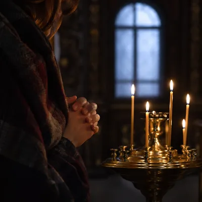 Folded Hands in Prayer by Candlelight