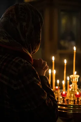 Folded Hands in Candlelit Prayer