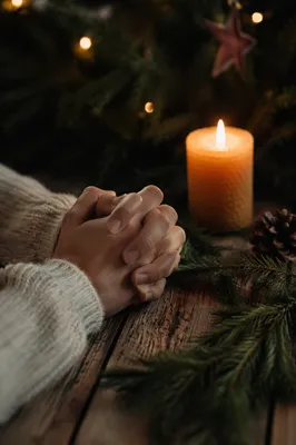 Candlelit Prayer Hands with Evergreen Sprigs
