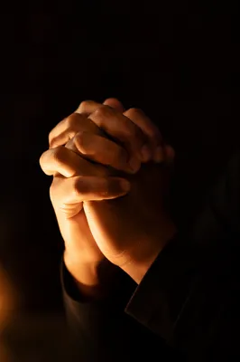Folded Hands in Warm Candlelight Prayer