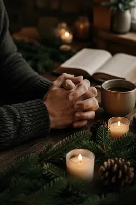 Folded Hands Praying by Candlelit Evergreens