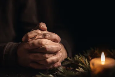 Candlelit Praying Hands with Evergreen Sprigs
