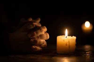 Folded Prayer Hands by Candlelight
