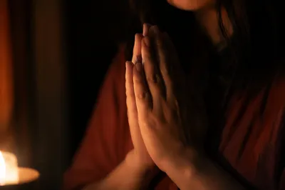 Candlelit Hands Folded in Quiet Prayer