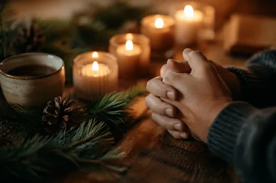 Folded Prayer Hands by Evergreen Candlelight
