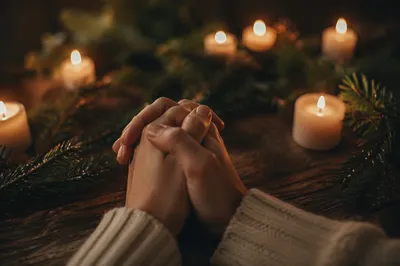 Hands Folded in Prayer by Candlelight