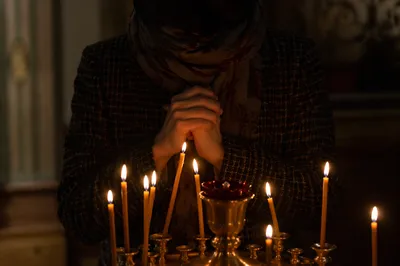 Folded Hands in Candlelight Prayer
