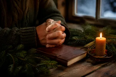 Candlelit Prayer Hands with Evergreen Sprigs