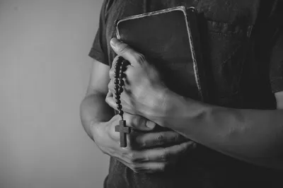 Hands Holding Bible in Reverent Prayer