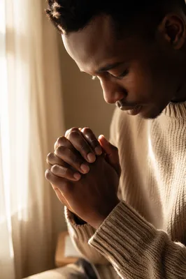 Young Man Praying by Sunlit Window