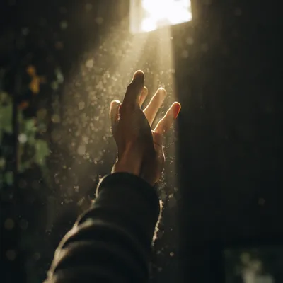 Hand Reaching Toward Hopeful Sunlight