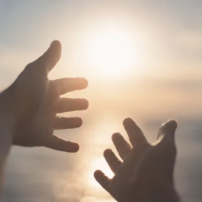 Hands Reaching Toward Hopeful Sunlight
