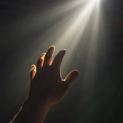 Hand Reaching Toward Hopeful Divine Light