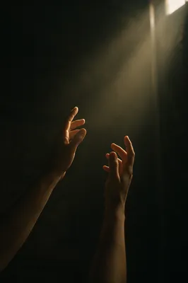 Hands Reaching Toward Warm Hopeful Light