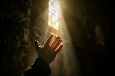 Hand Reaching Toward Hopeful Sunlight