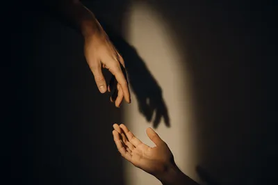 Hands Reaching Toward Warm Light