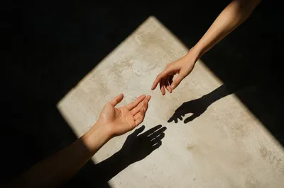 Hands Reaching Toward Hopeful Light