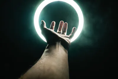 Hand Reaching Toward Halo Light