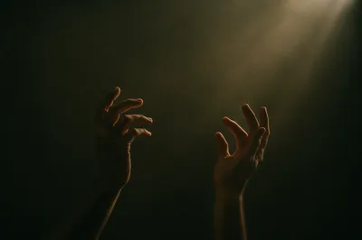 Hands Reaching Toward Warm Light