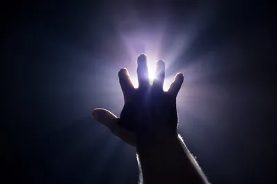 Hand Reaching Toward Divine Light