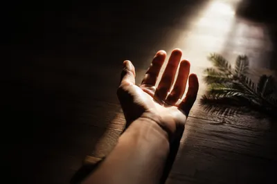 Hand Reaching Toward Hopeful Sunlight