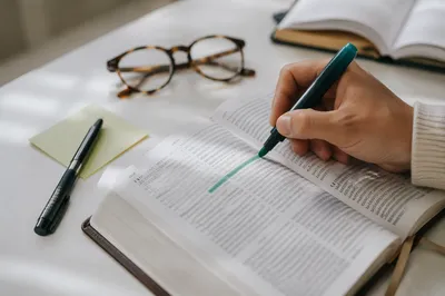 Hand Highlighting Passage in Open Book
