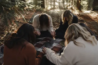 Intercessory Prayer Circle Beneath Evergreen Trees