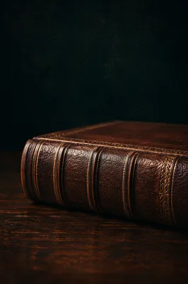 Brown Leather Bible on Dark Wooden Table
