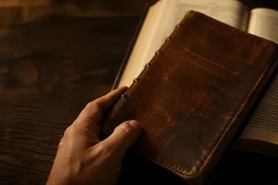 Worn Leather Bible on Dark Walnut Table