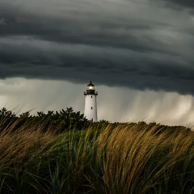 White Lighthouse Beacon Beneath Storm Clouds