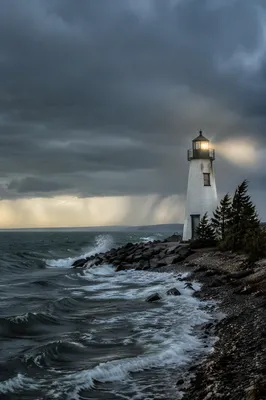 Lighthouse Beacon Through Stormy Evergreen Coast