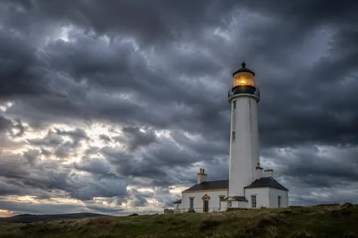 Lighthouse Beacon Shining Through Storm Clouds