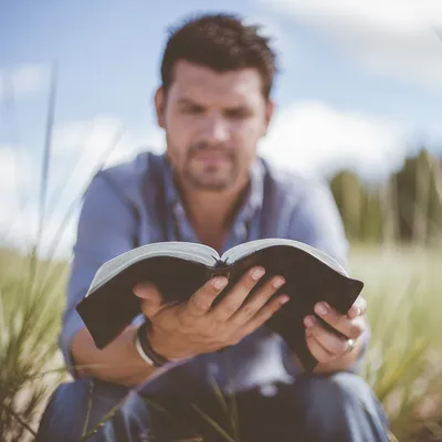 Man Reading Bible in Morning Coastal Light