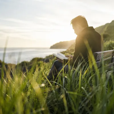 Man Reading Bible in Morning Coastal Light