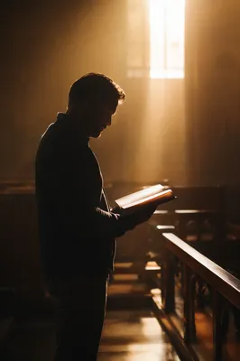 Man Reading Bible in Morning Chapel Light