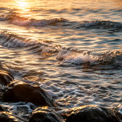 Golden Sunrise Waves Over Rocky Shore