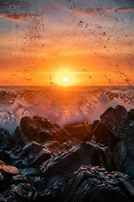 Sunrise Waves Crashing Over Coastal Rocks